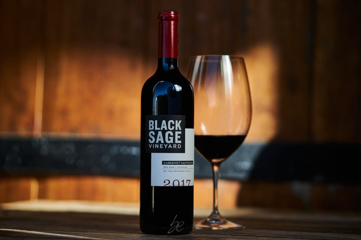 Red wine glass and wine bottle at sunset at winery by kelowna photographer